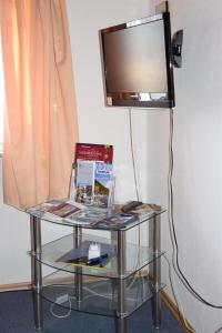 a glass table with a television on a wall at Pension Wiesner in Hameln