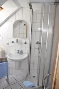 a white bathroom with a sink and a shower at Pension Wiesner in Hameln