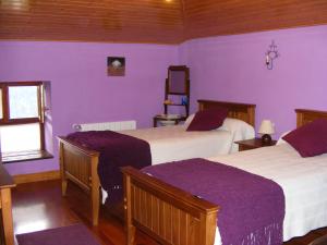 una camera con due letti e pareti viola di Casa Rural Altzuste Landetxea a Zeanuri