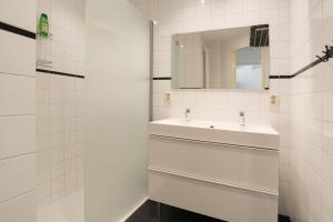 a white bathroom with a sink and a mirror at Central Rooftop Terrace Guest Suite in Amsterdam