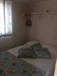 a bed with two pillows on it in a bedroom at Casa no Monte Ninho das Perdizes perto Cercal do Alentejo in Vale de Água