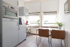 a kitchen with a table with chairs and a refrigerator at Central Rooftop Terrace Guest Suite in Amsterdam +18 photos