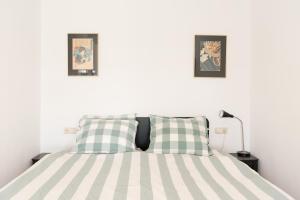 a bedroom with a bed with two pictures on the wall at Central Rooftop Terrace Guest Suite in Amsterdam