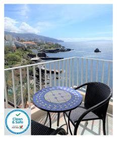フンシャルにあるApartamento do Mar e Luaの海を見渡すバルコニー(テーブル、椅子付)