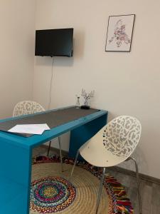 a blue desk with two chairs and a television at Süßes Zimmer im Souterrain in Frensdorf