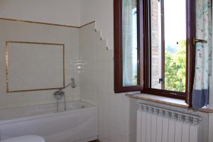 a bathroom with a tub and a sink and a window at La Sorgente Del Sole in San Severino Marche