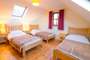 a bedroom with two beds and a window at Croagh Patrick Hostel & Cottages Resort in Murrisk