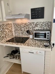 a kitchen with a counter top with a microwave at Havgassens in Sæby