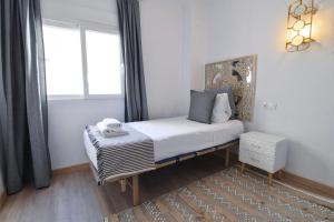 - un petit lit dans une chambre avec fenêtre dans l'établissement Cremades Duke Apartment, à Malaga