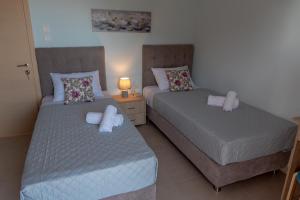 two beds sitting next to each other in a bedroom at Dimi Seafront Apartment by Rentals Pro - Nea Moudania in Nea Moudania