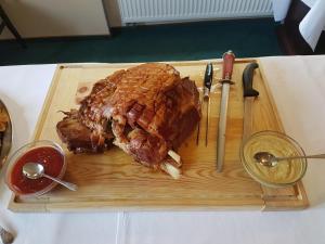 a wooden cutting board with a piece of meat on it at Hotel Starý Mlýn in Mlýnec