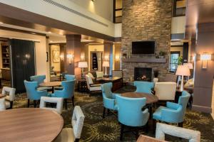 a lobby with tables and chairs and a fireplace at Staybridge Suites Albany Wolf Rd-Colonie Center, an IHG Hotel in Albany