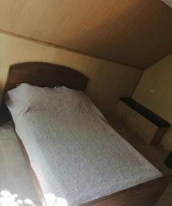 スルグトにあるHotel Klenのベッドルーム1室(木製ヘッドボード付きのベッド1台付)