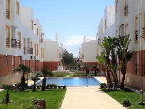 a courtyard with a swimming pool between two buildings at Apartamento Vista Mar in Cabanas de Tavira