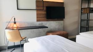 una camera con letto, scrivania e sedia di SCOTTY & PAUL Hotel Deggendorf a Deggendorf