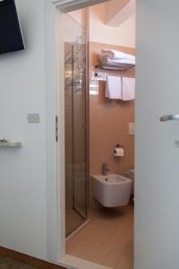 a bathroom with a glass shower and a sink at Hotel Brig in Riccione