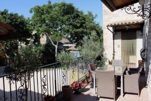 a patio with a fence and chairs and a tree at La Sorgente Del Sole in San Severino Marche