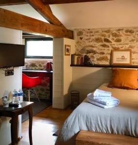 1 dormitorio con cama, mesa y ventana en La Blanchisserie en Le Puy-Saint-Bonnet