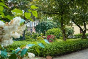 ogród z kwiatami i drzewami przed budynkiem w obiekcie Ego Apartments Old Town w Warszawie