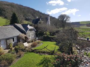 an old house with a garden and a hill at Stable Cottage "The Unicorn Stable" in Yelverton