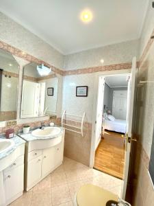 a bathroom with two sinks and a large mirror at Serva La Bari Rooms in Seville