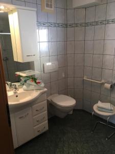 een badkamer met een toilet, een wastafel en een spiegel bij Appartements Caroline in Ossiach