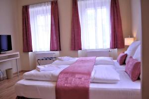 sypialnia z dużym łóżkiem i 2 oknami w obiekcie Penzion Lípa w mieście Krásná Lípa