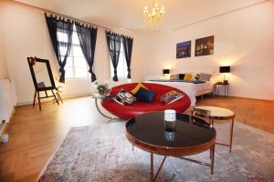 - un salon avec un canapé rouge et un lit dans l'établissement Fano Apartments Old Town Prague, à Prague