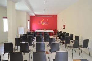 a room with chairs and a table and a red wall at Aparthotel El Cerrito in Los Cancajos +34 photos