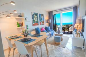 a dining room and living room with a table and chairs at Palma Fiesta Apartment by Hello Homes Sitges in Sant Pere de Ribes