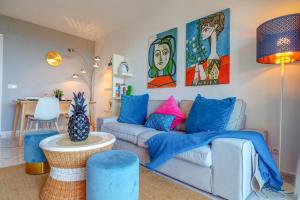 a living room with a couch with colorful pillows at Palma Fiesta Apartment by Hello Homes Sitges in Sant Pere de Ribes