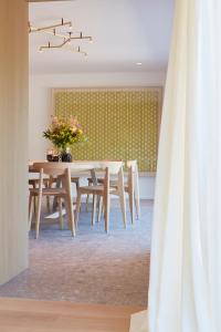 a dining room with a table with flowers on it at Les Pommiers in Ellezelles