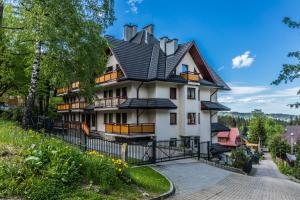 a large white house with a black roof at Nosal Hill Apartments&Spa in Zakopane