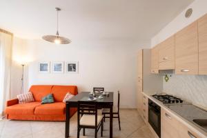 a living room with an orange couch and a table at Marina Apartment in San Benedetto del Tronto +13 photos