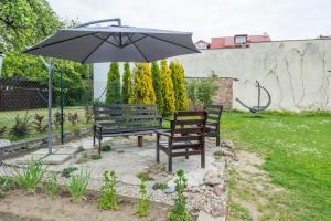 グディニャにあるŻÓŁTE RÓŻEの庭の傘下に座るベンチ2つ