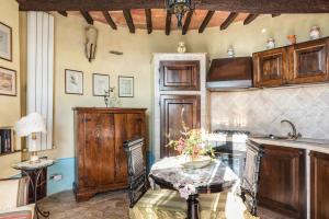 une cuisine avec des placards en bois et une table dans l'établissement Borgo Sanguineto, à Tuoro sul Trasimeno