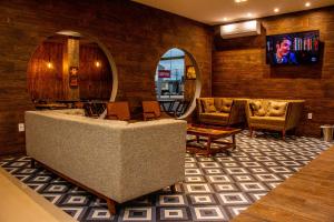 a lobby with a couch and chairs and a tv at INACIO'S PLAZA HOTEL in Marabá