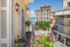 a balcony with flowers and a view of a street at Kâmara Old Town Studios in Corfu Town