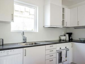 a kitchen with white cabinets and a sink and a window at Holiday home STRÖMSTAD XV in Strömstad
