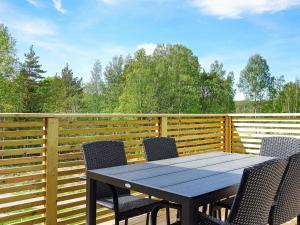 une terrasse en bois avec une table et des chaises. dans l'établissement Holiday home STRÖMSTAD XVIII, à Strömstad