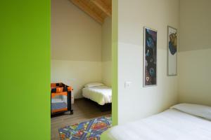 a room with two beds and a green wall at Hotel Marelet in Treviglio