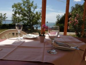 a table with two wine glasses on top of it at Apartmani nana in Starigrad-Paklenica