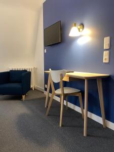 Cette chambre dispose d'une table, d'une chaise et d'une télévision. dans l'établissement Hotel Colbert, à Tours