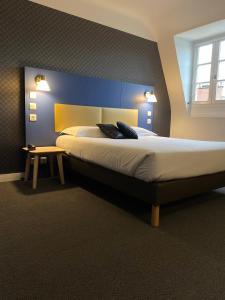 um quarto com uma cama grande e uma parede azul em Hotel Colbert em Tours