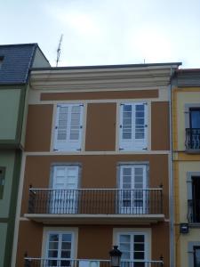 um edifício castanho com janelas brancas e uma varanda em SAN FRANCISCO em Ribadeo