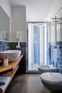 uma casa de banho com 2 lavatórios e uma cabina de duche em vidro. em Hotel Madison em Rimini