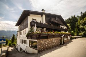 um edifício com uma varanda com flores em Canisiusbrünnl Self- Check in em Innsbruck