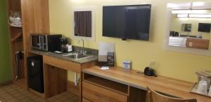 a kitchen with a sink and a tv on the wall at Microtel Inn & Suites by Wyndham Delphos in Delphos