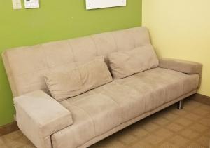 a white couch in a room with a green wall at Microtel Inn & Suites by Wyndham Delphos in Delphos