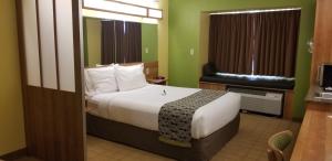 a hotel room with a bed and a window at Microtel Inn & Suites by Wyndham Delphos in Delphos